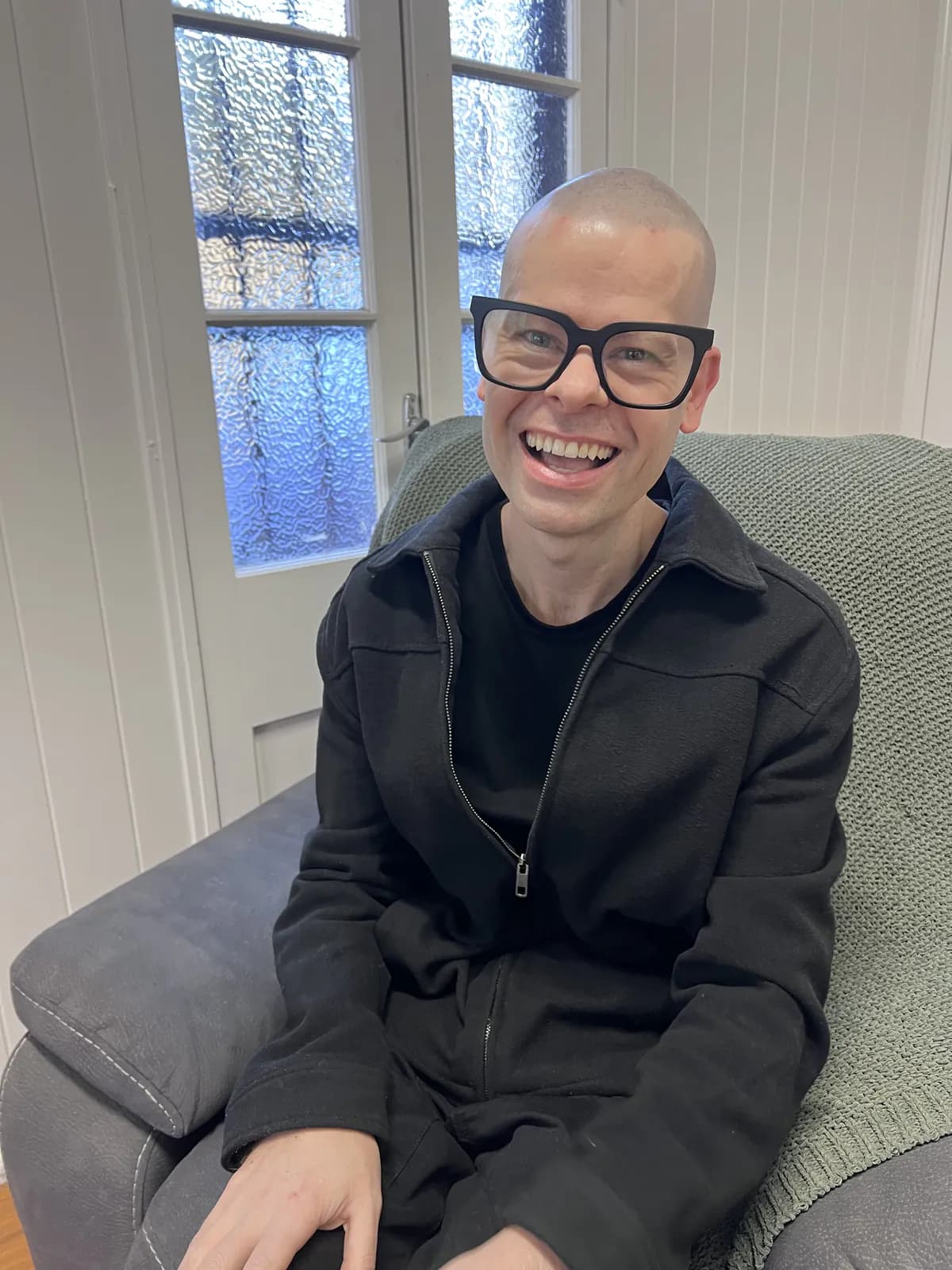 Ben seated on a couch in the clinic waiting area at the start of his treatment day.